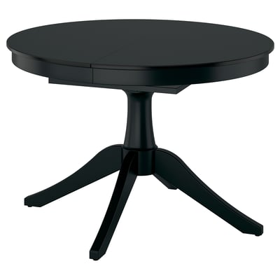 Black extendable dining table with round top and pedestal base, seats up to six.