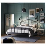 Modern bedroom featuring SAGSTUA bed with brass accents, white bedding, teal walls, and pendant lights.