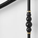 Black bed leg with brass accents for sturdy support.