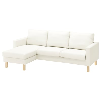 A white SALTSJÖBADEN sectional sofa with a light fabric, slight texture, wooden legs, and a corner chaise lounge.