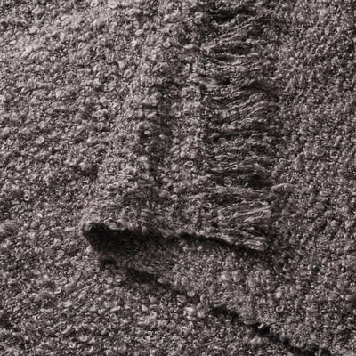 A grey, rectangular SANDBRODD throw blanket with a crinkled texture and fringe ends, made from 100% recycled polyester.