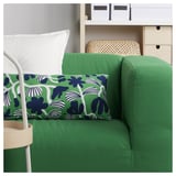 Displays a green SANDMOTT cushion with blue floral patterns on a matching green sofa.