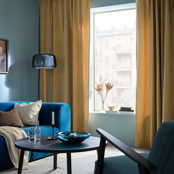 SANELA curtains in beige-yellow perfectly frame large window, enhancing rooms cozy, luxurious feel.