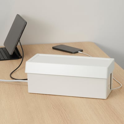 White SÄTTING box organizes desk cables on wooden desk.