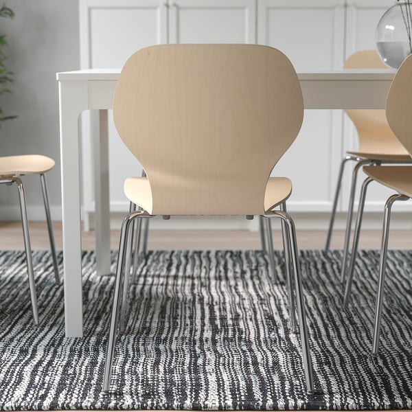 Chairs with curved backs for comfort, stacked neatly. Black and white striped rug underneath.