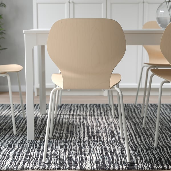 Chairs around dining table, showcasing stackability for space efficiency.