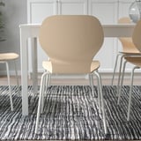 Chairs around dining table, showcasing stackability for space efficiency.