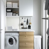 Small white SKÅDIS pegboard organized with tools & notes above a washing machine in a laundry room.