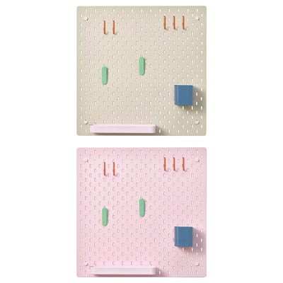 Displays two SKÅDIS pegboards in beige and pink colors, featuring organized pegs and accessories.