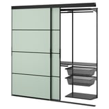 SKYTTA wall unit: green panels, black metal, sliding door, mesh shelves.