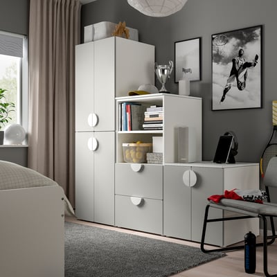 Modern bedroom with SMÅSTAD white wardrobe, drawers, shelves, and sports décor.