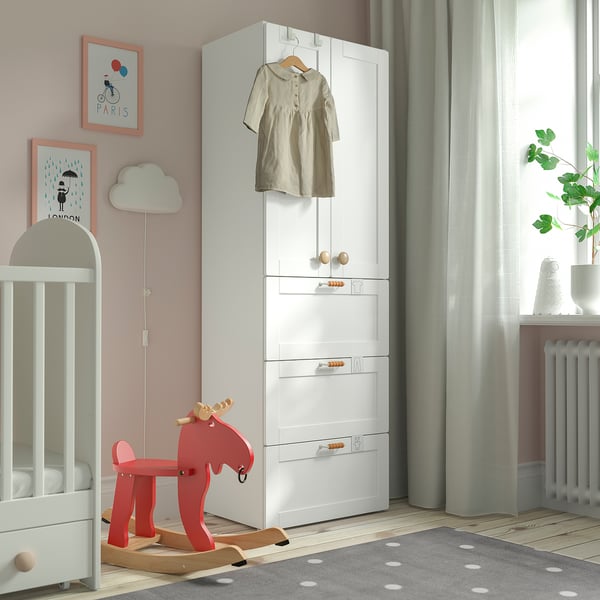 Cozy nursery with white SMÅSTAD wardrobe, red rocking horse, crib, and polka dot rug.