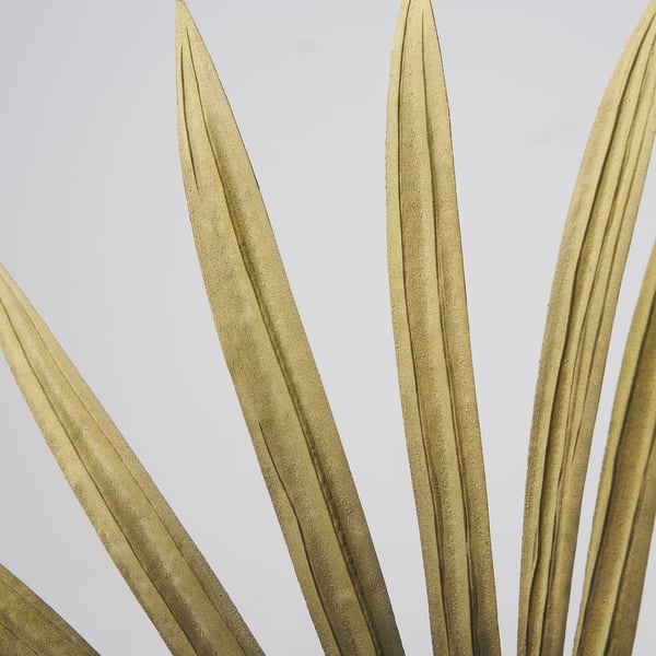 Luxurious gold artificial grass blades, realistic and crafted with precision, displayed against a light background.