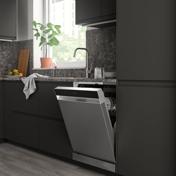 Modern dark kitchen featuring an open SÖDERBODA dishwasher, smaller than surrounding cabinets, near a window with a plant.