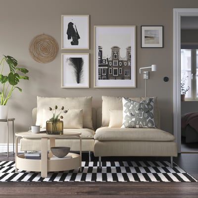 Modern living room with grey SÖDERHAMN sofa, black & white rug, art wall, plants, and chic decor.