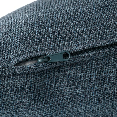 Close-up of a modern, deep-seated sofa with a sleek, silver zipper on a textured, woven fabric.