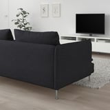 Ikea SÖDERHAMN sofa in dark grey, low-profile design against white wall, with tv stand, tv, and plant.