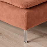 A close-up of a cushioned seat in light brown fabric on a polished metallic leg, showcasing high-quality upholstery.
