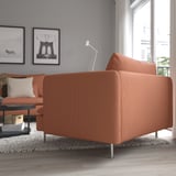 A modern living room an orange SÖDERHAMN sofa with deep seating and high legs. The sofas stylish, low profile provides comfort and relaxation.