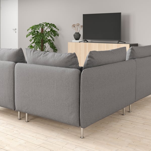 Modern living room with a SÖDERHAMN gray sofa, wooden tv stand, flat screen tv, and a tall indoor plant.