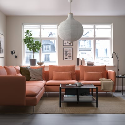 Modern living room with orange SÖDERHAMN sectional, large window, pendant lamp, plant, patterned pillows, and coffee table.