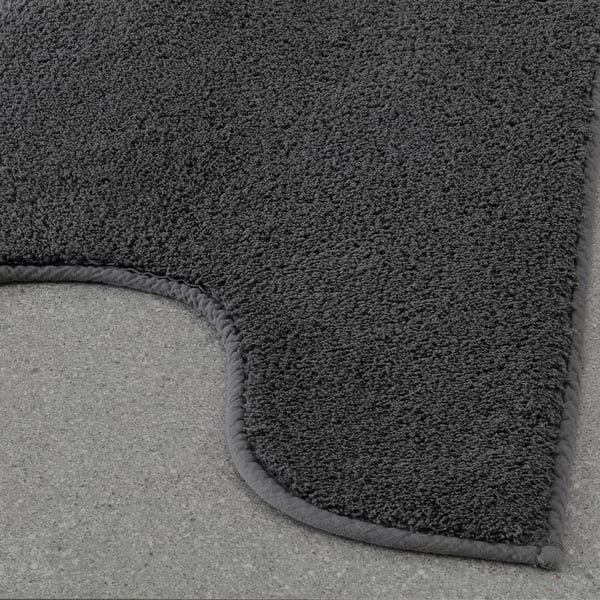 Close-up of dark grey plush mat with thick, soft cotton pile and textured latex backing, displayed on a flat surface.