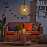 Orange sofa, pillows, coffee table, string lights, plant, decor.