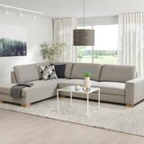 Minimalist living room with l-shape sofa, coffee table, large windows, nature view.