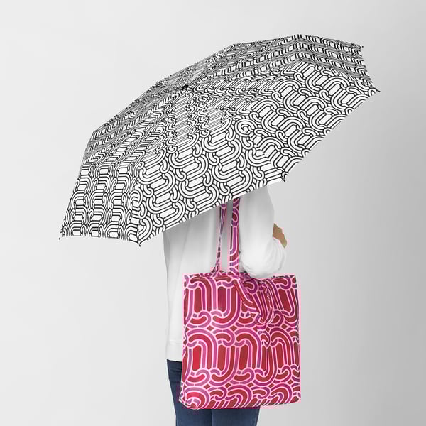 Person with SÖTRÖNN umbrella and red recycled polyester shoulder bag.