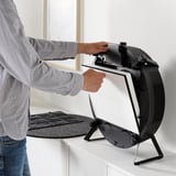 Person installs air purifier filter on a white surface.