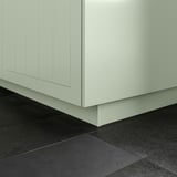 Close-up of white STENSUND plinth, filling gap between kitchen cabinet and dark floor.