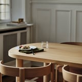 Linen napkin from STOCKHOLM 2025, absorbs liquid, fits plates on wood table.