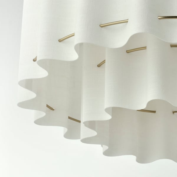 Elegant pendant lamp with wavy textile shade and gold accents, exuding a soft, inviting light.
