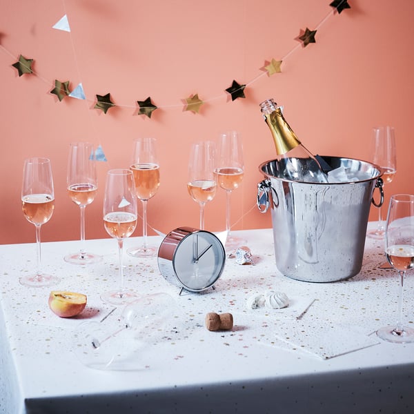 Champagne glasses & ice bucket on table, decorated with star garland.