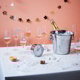 Champagne glasses & ice bucket on table, decorated with star garland.