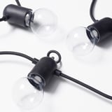 Modern string lights with black casings and clear globes for outdoor decorative lighting.
