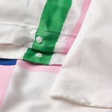Close-up of a multicolour duvet cover with hand-drawn check pattern and plastic press-stud closure.