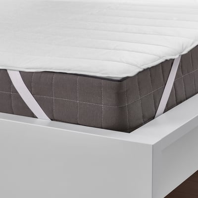 White mattress protector on bed, elastic straps for secure fit, protects mattress from stains.