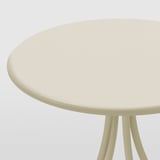 Round beige side table with three legs, smooth and sturdy surface.