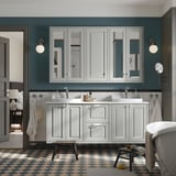 Modern bathroom with large TÄNNFORSEN white vanity, double sinks, grey walls. Checkered floor, round mirrors.