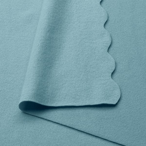 Soft light blue recycled polyester blanket, folded neatly, showcasing its smooth texture.