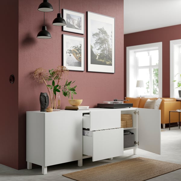 White cabinet with open doors revealing organized items, including records and wooden boxes.