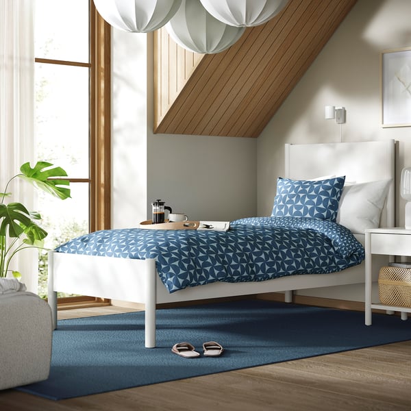 TONSTAD bed, classic design, sturdy, with lamps, rug, plant, side table, geometric bedding.