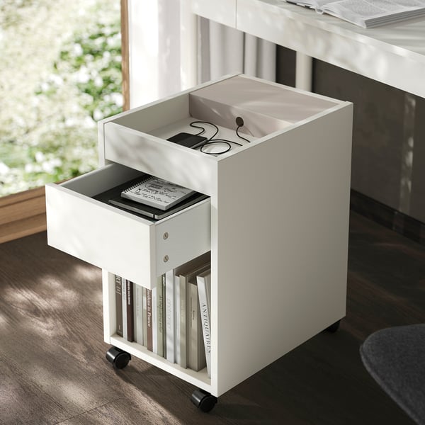 White mobile storage cart with drawer and shelves, ideal for small items, positioned under a desk.
