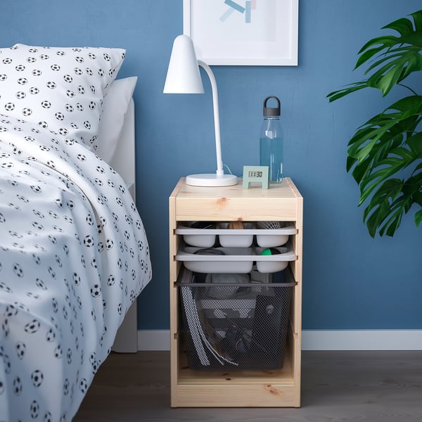 TROFAST bedside table with lamp, bottle, clock, soccer bedding, plant.