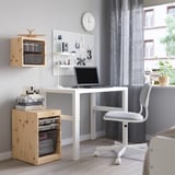 TROFAST desk, storage units, swivel chair, clock, lamp, laptop - neat, modern home office setup.