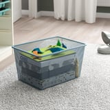 Metal mesh storage bin on carpet, containing colorful translucent plastic organizers.