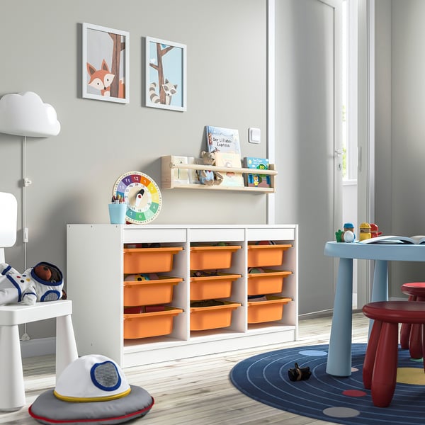 Childrens room with TROFAST storage unit featuring orange plastic boxes and white frame. The large, low unit holds toys, books, and has playful decor.