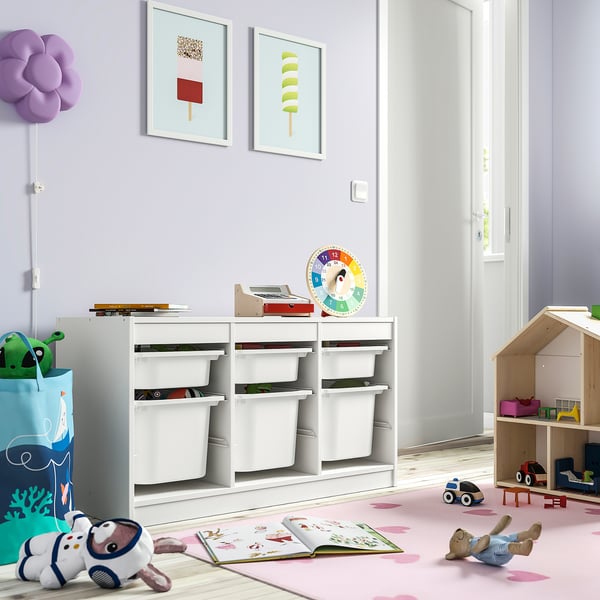 Bright kids room with white TROFAST storage, colorful toys, and pastel decor. Large, low unit fits well under vibrant art prints.