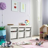 Bright kids room with white TROFAST storage, colorful toys, and pastel decor. Large, low unit fits well under vibrant art prints.
